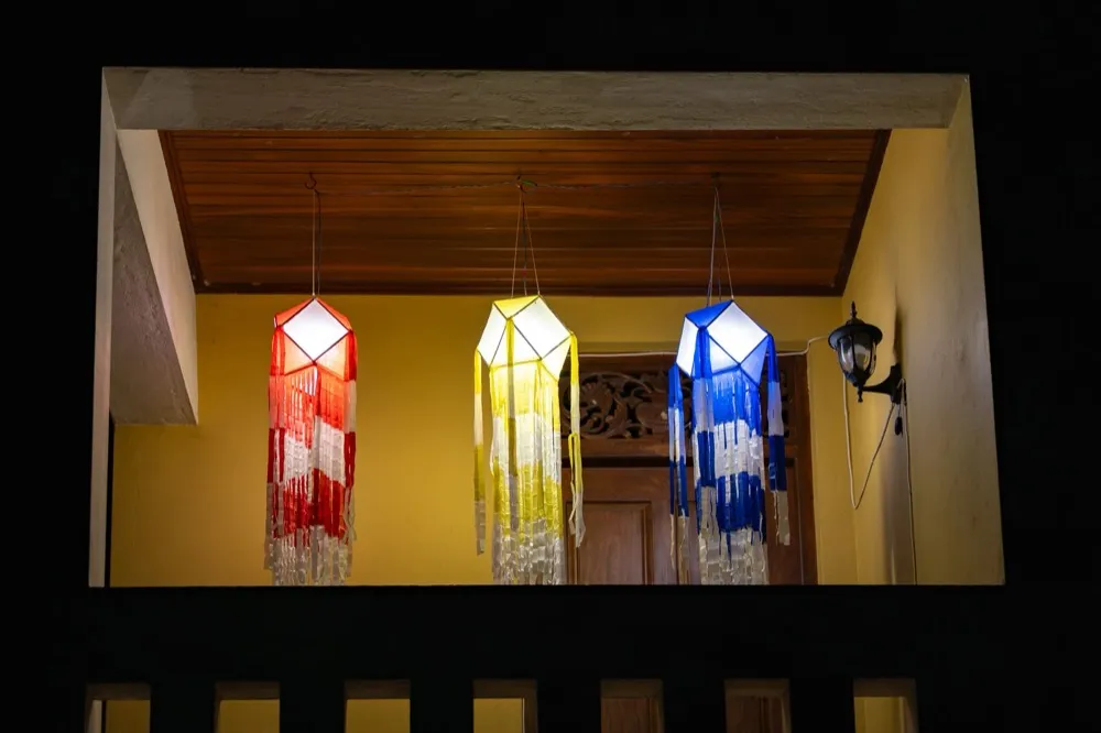 Three colourful fringed festival lanterns glowing at night